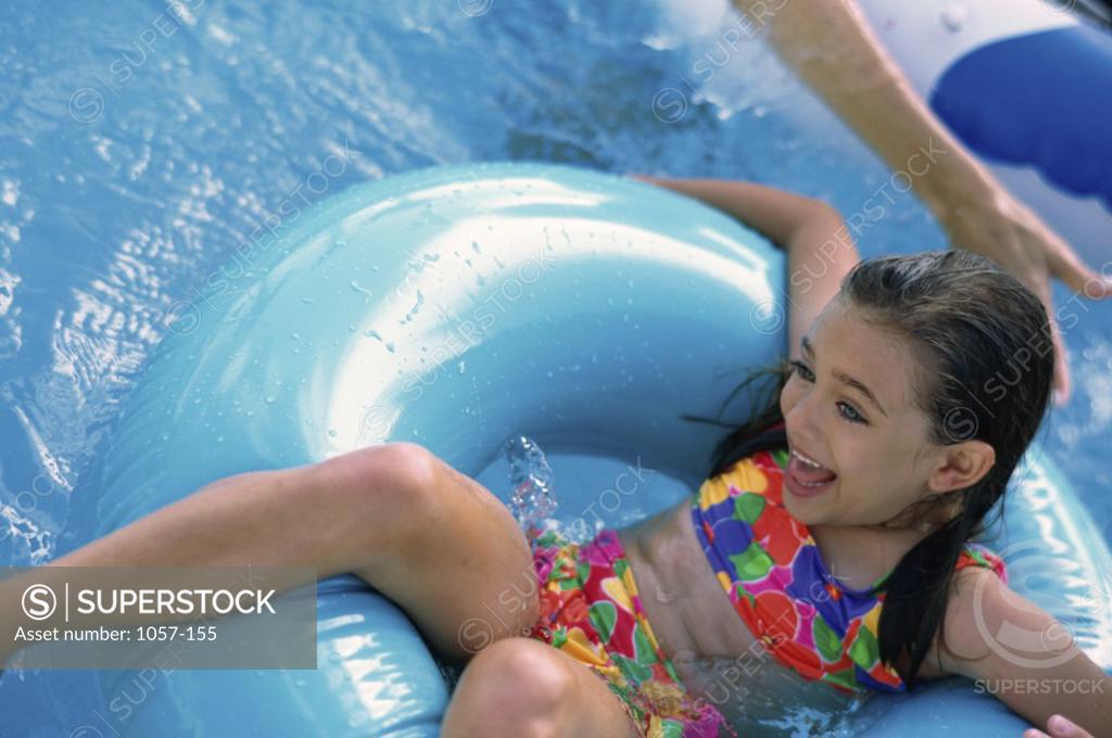 Stock Photo: 1057-155 Girl sitting on an inflatable ring in a swimming pool