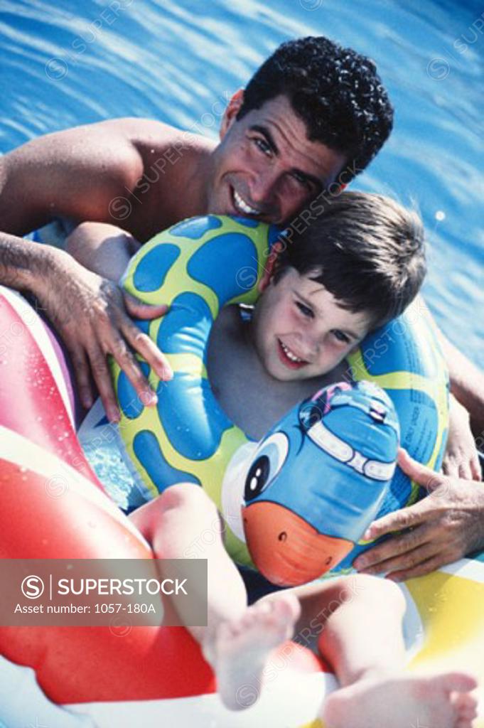 Stock Photo: 1057-180A Portrait of a mid adult man with his son in a swimming pool and smiling