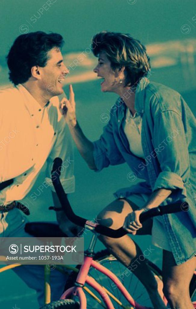 Stock Photo: 1057-193A Mid adult couple with bicycles on the beach