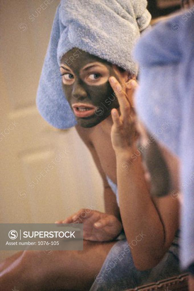 Stock Photo: 1076-105 Young woman applying a facial mask
