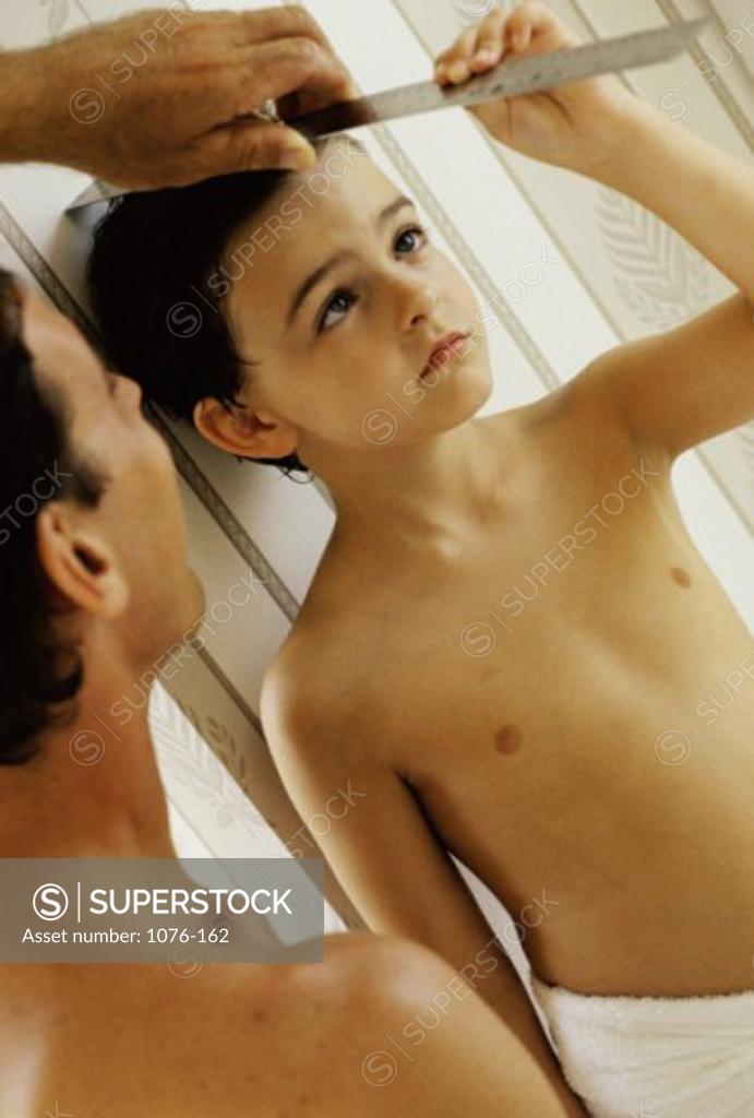 Stock Photo: 1076-162 Father measuring his son's height