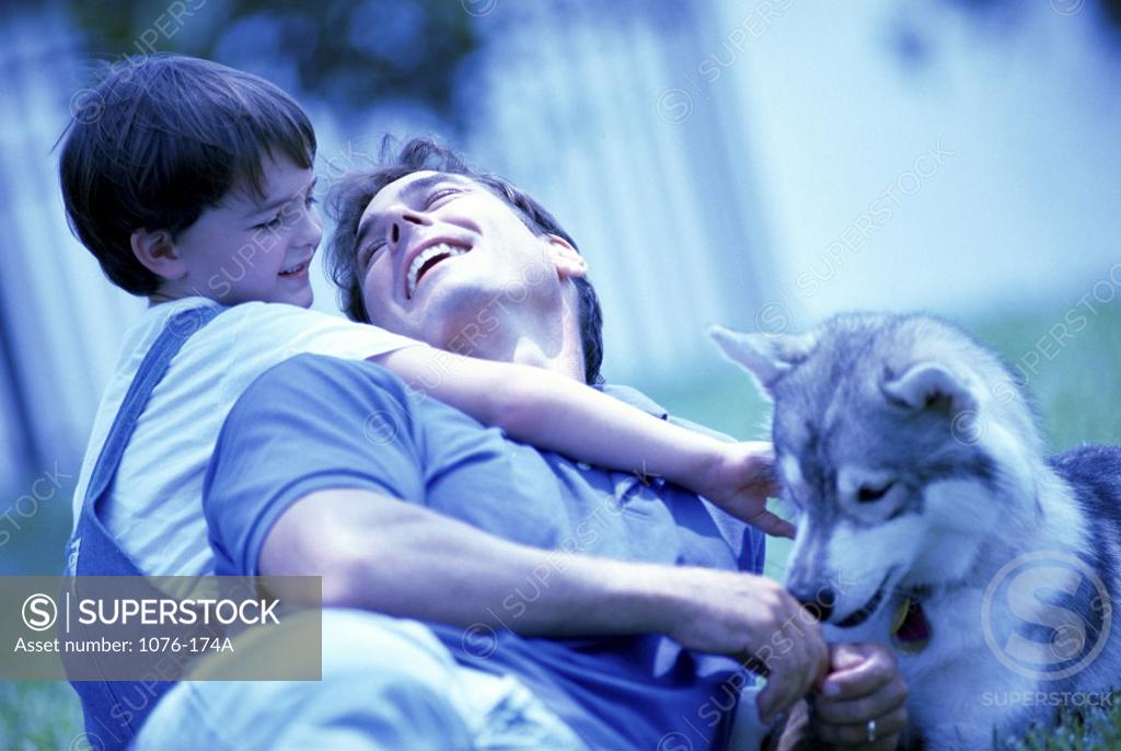 Stock Photo: 1076-174A Father and his son sitting in front of their dog
