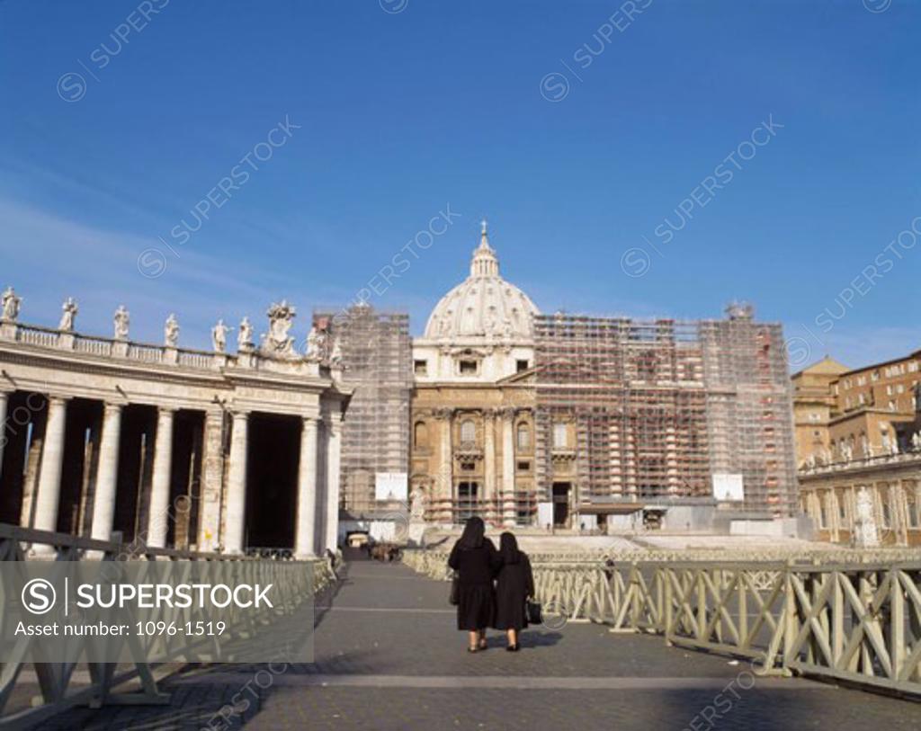 Stock Photo: 1096-1519 Rear view of two women walking in front of a basilica, St. Peter's Basilica, St. Peter's Square, Vatican City