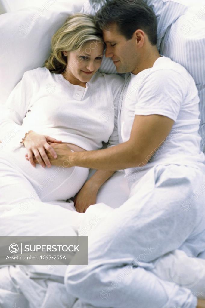 Stock Photo: 1097-255A Husband lying in bed with his pregnant wife