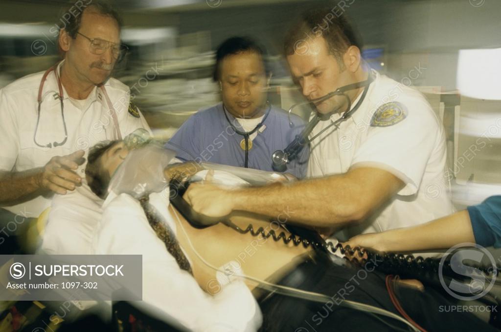 Stock Photo: 1097-302 Paramedics pushing a man on a stretcher