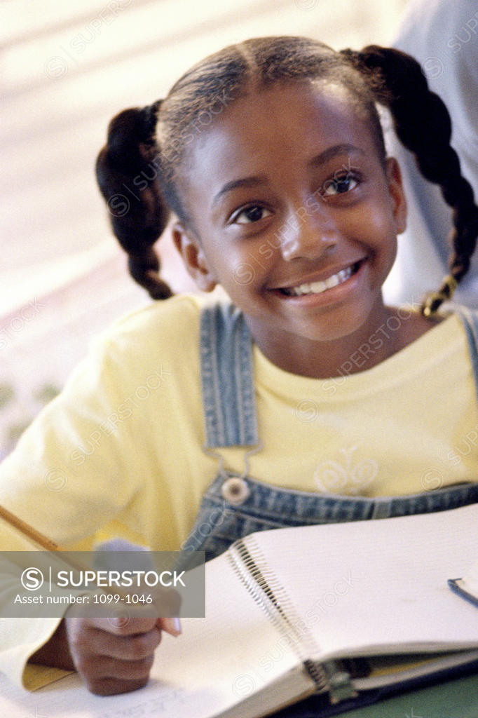 Stock Photo: 1099-1046 Portrait of a girl writing in a notebook