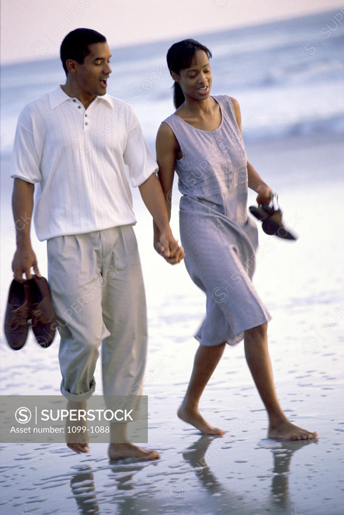 Stock Photo: 1099-1088 Young couple walking on the beach