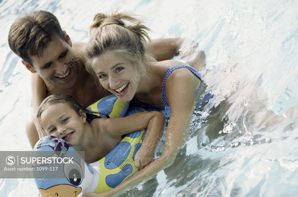 Stock Photo: 1099-117 Portrait of a young couple playing in a swimming pool with their daughter