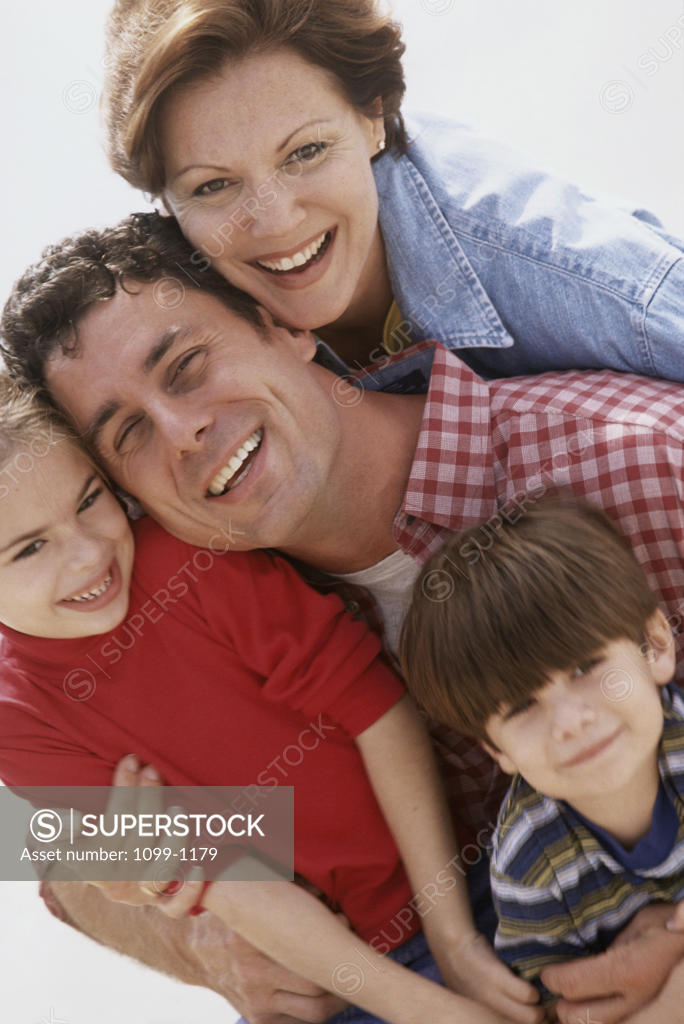 Stock Photo: 1099-1179 Portrait of a mid adult couple with their son and daughter smiling