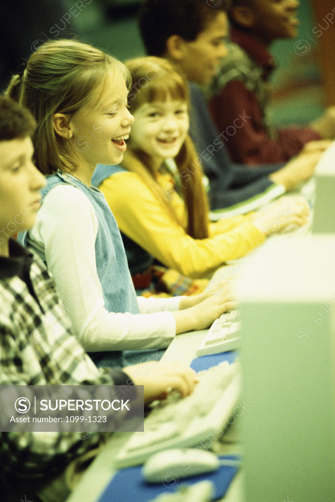 Stock Photo: 1099-1323 Side profile of a group of children in front of computers