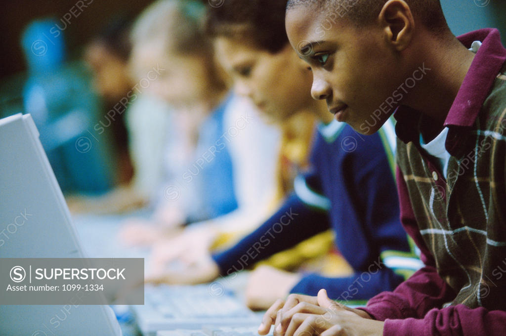 Stock Photo: 1099-1334 Side profile of students in a classroom working on computers