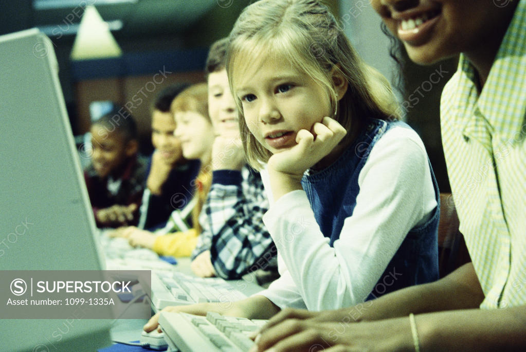 Stock Photo: 1099-1335A Side profile of a group of children in front of computers