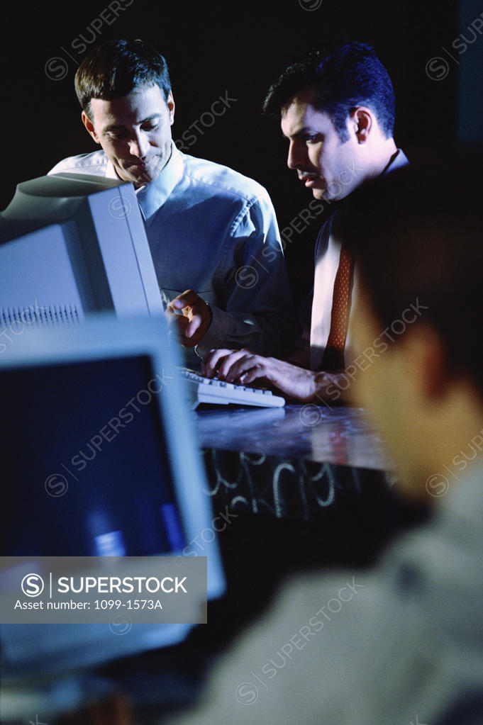 Stock Photo: 1099-1573A Three businessmen working in an office