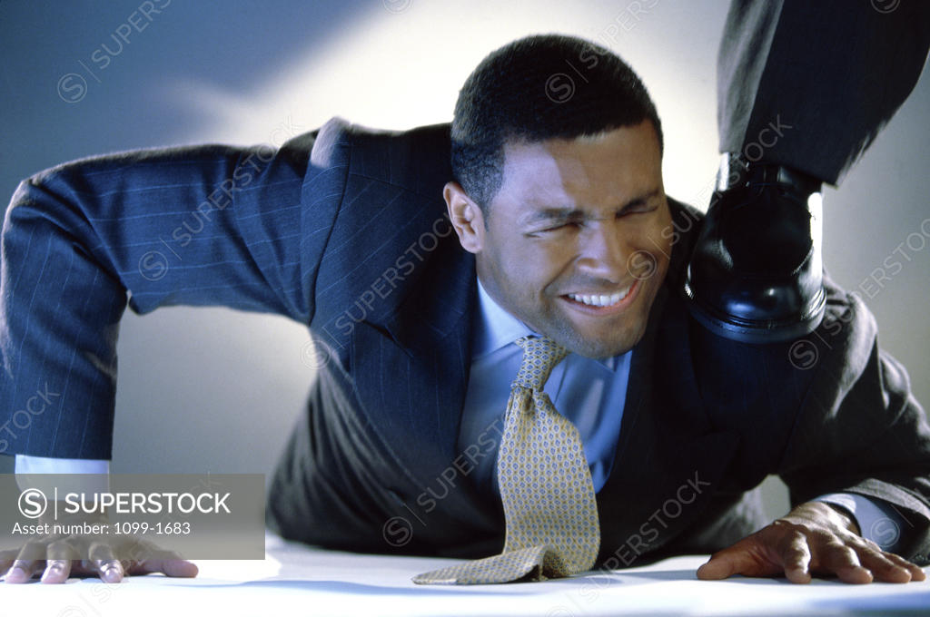 Stock Photo: 1099-1683 Businessman pushed down by a person's foot