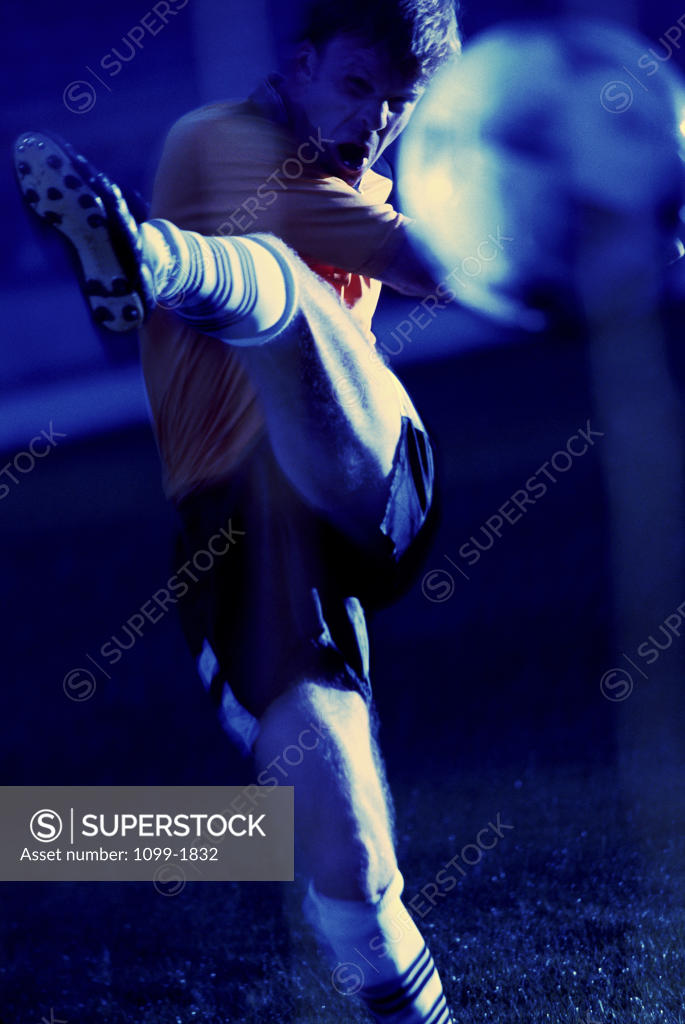 Stock Photo: 1099-1832 Soccer player kicking a soccer ball