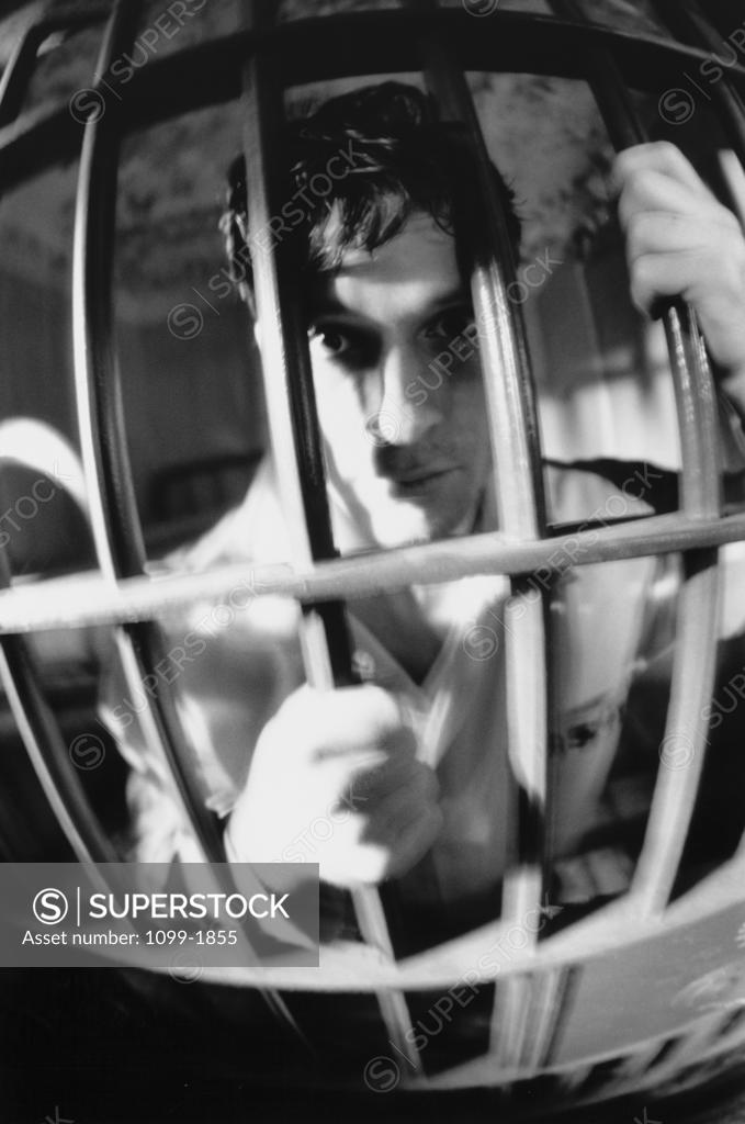 Stock Photo: 1099-1855 Portrait of a mid adult man in a prison cell