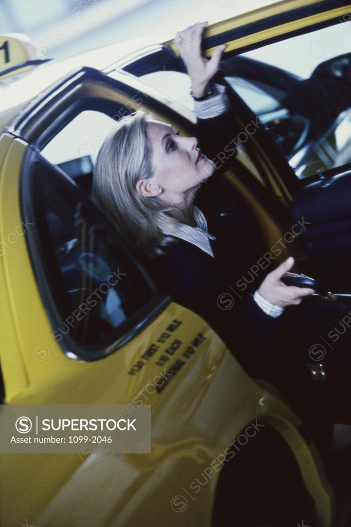 Stock Photo: 1099-2046 Businesswoman exiting a taxi