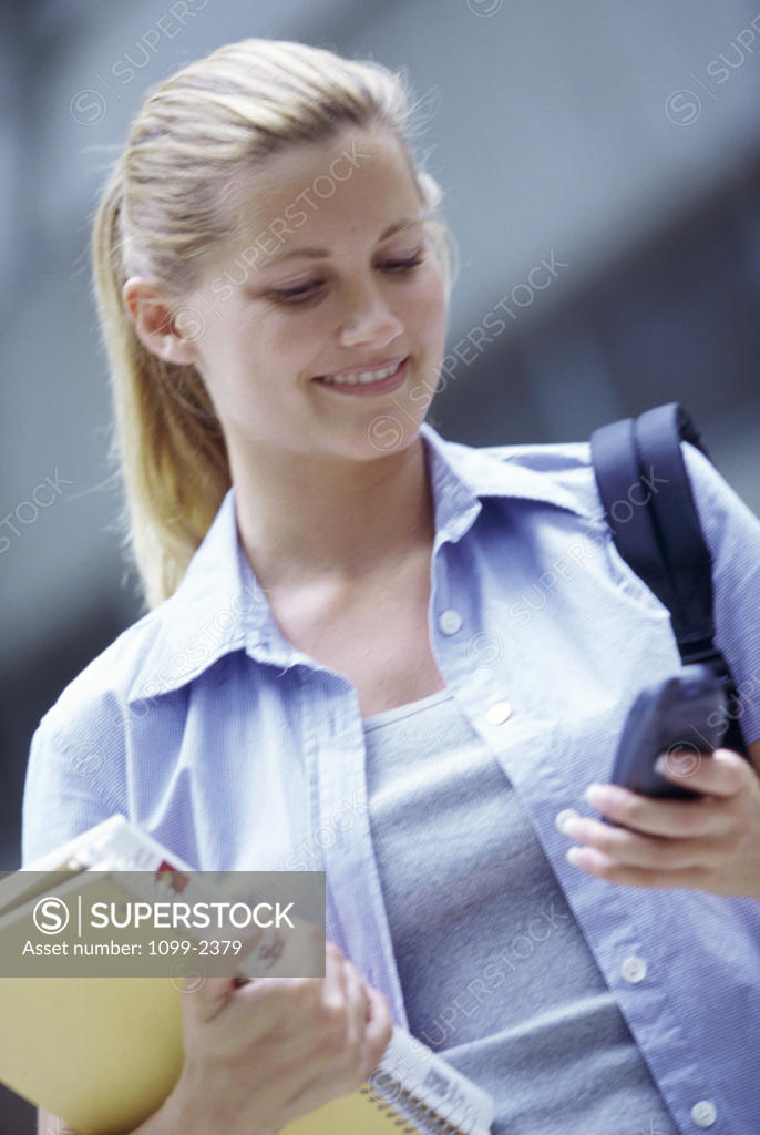 Stock Photo: 1099-2379 Teenage girl operating a mobile phone