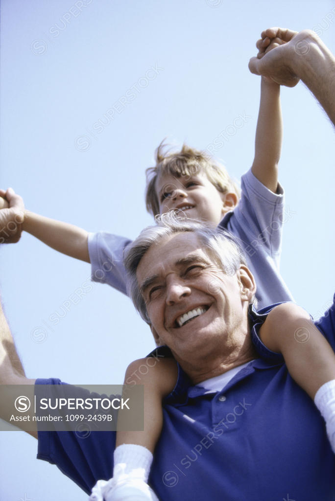 Stock Photo: 1099-2439B Grandfather carrying his grandson on his shoulders