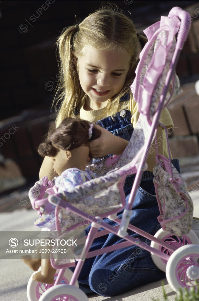 Stock Photo: 1099-2693B Girl playing with a doll