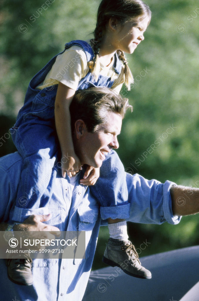 Stock Photo: 1099-2718 Father carrying his daughter on his shoulders