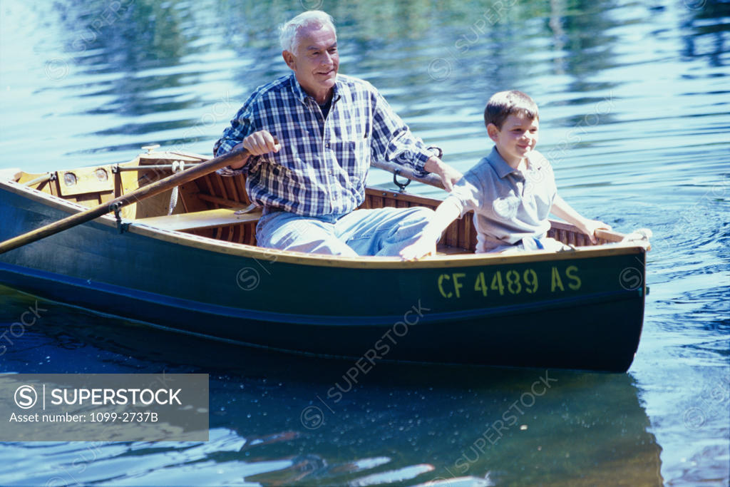 Stock Photo: 1099-2737B Grandfather and his grandson in a row boat on the river