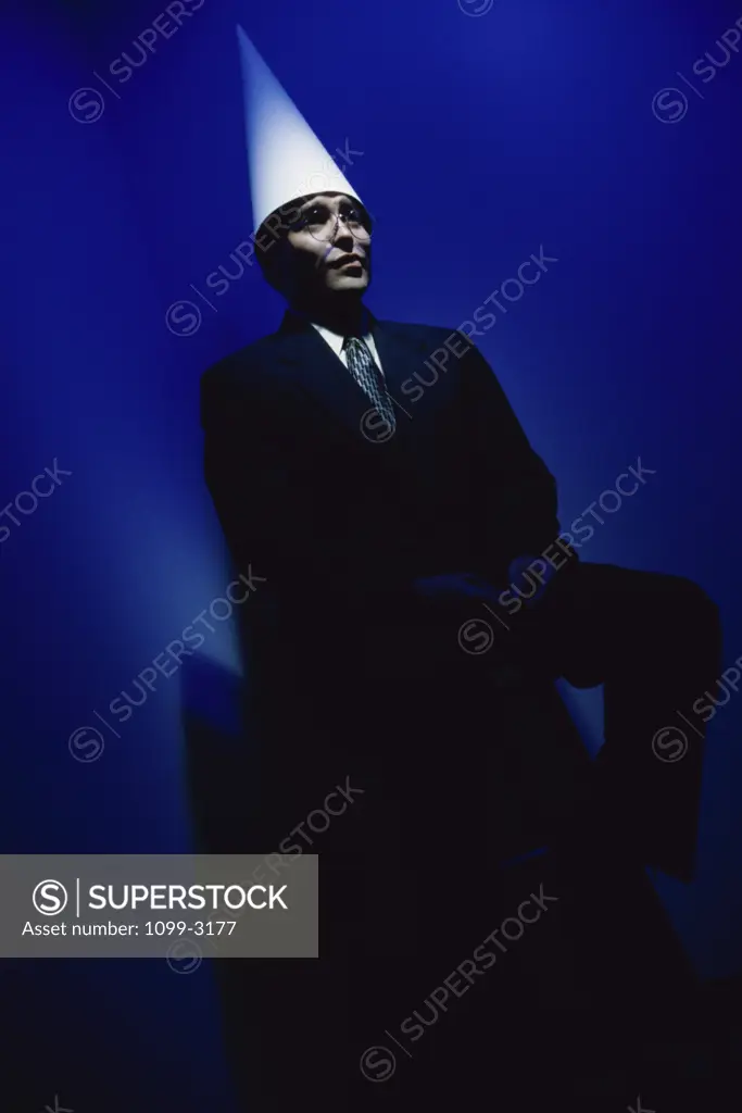 Businessman wearing a dunce cap