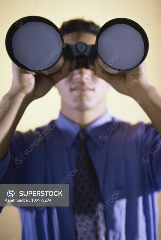 Stock Photo: 1099-3294 Businessman looking through a pair of binoculars