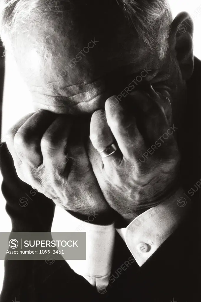Businessman covering his face with his hands
