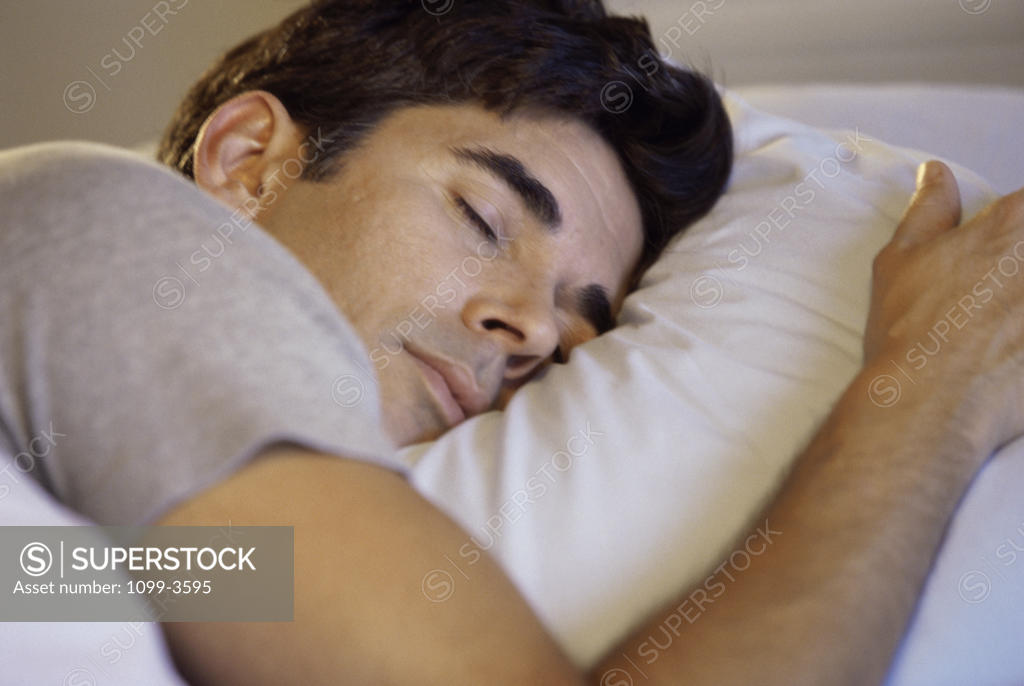 Stock Photo: 1099-3595 Close-up of a mid adult man sleeping on a bed