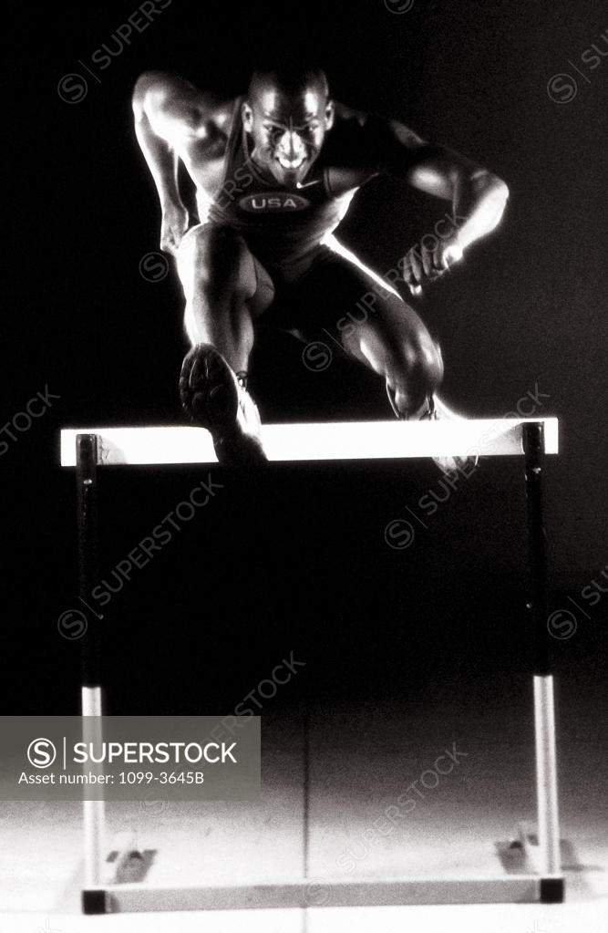 Stock Photo: 1099-3645B Portrait of a young man jumping over a hurdle