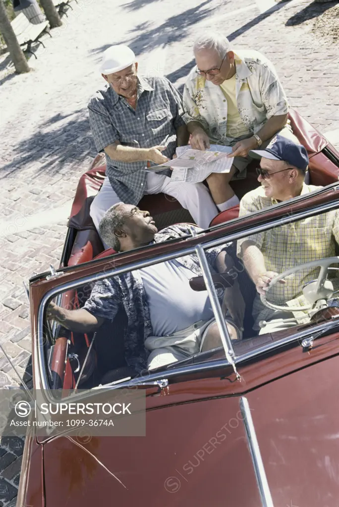 Three senior men traveling together in a convertible car