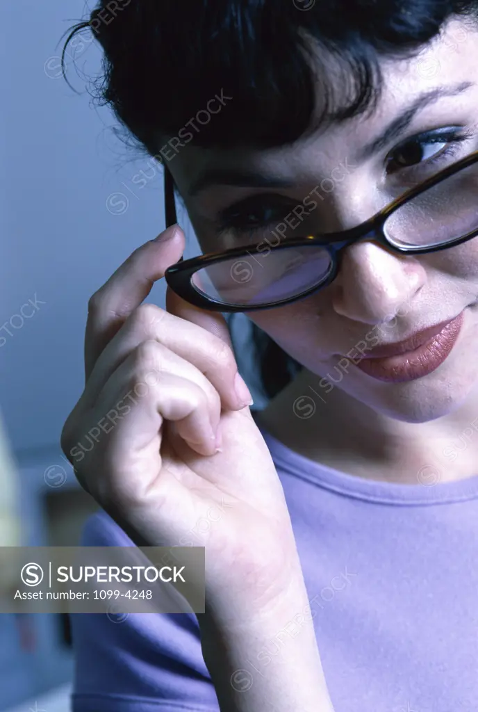 Close-up of a young woman holding her eyeglasses
