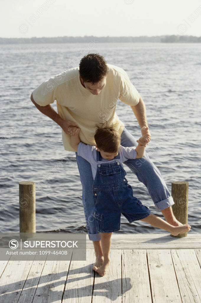 Stock Photo: 1099-4640B Mid adult man standing with his son on a pier