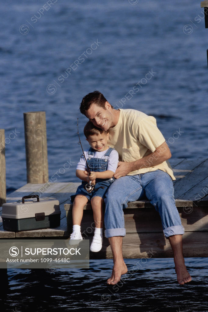 Stock Photo: 1099-4648C Father and his son sitting on a pier fishing