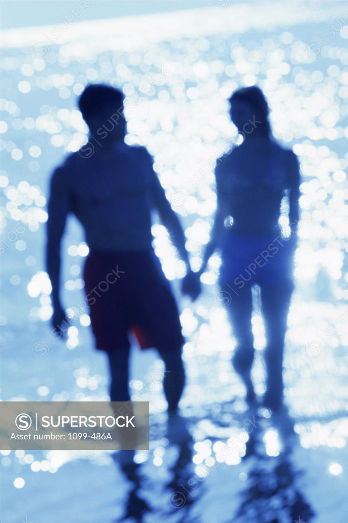 Stock Photo: 1099-486A Silhouette of a young couple walking on the beach