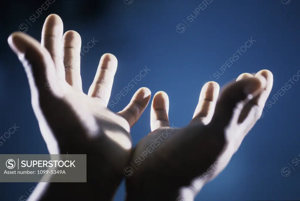 Close-up of a person's hands reaching up
