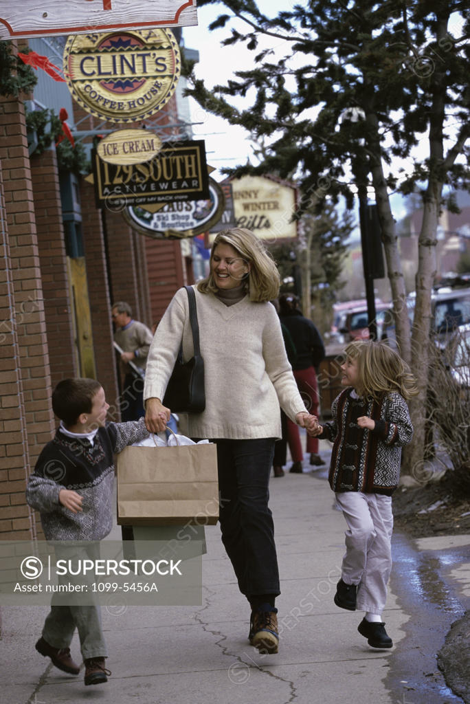 Stock Photo: 1099-5456A Mother walking on the sidewalk with her son and daughter