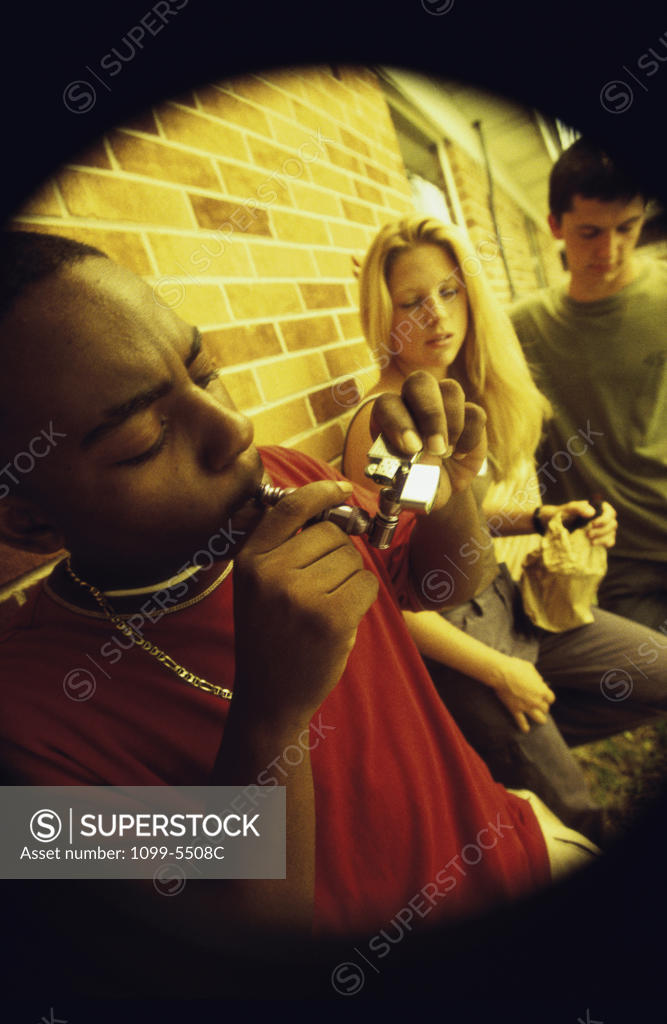 Stock Photo: 1099-5508C Side profile of a group of teenagers smoking opium in a pipe