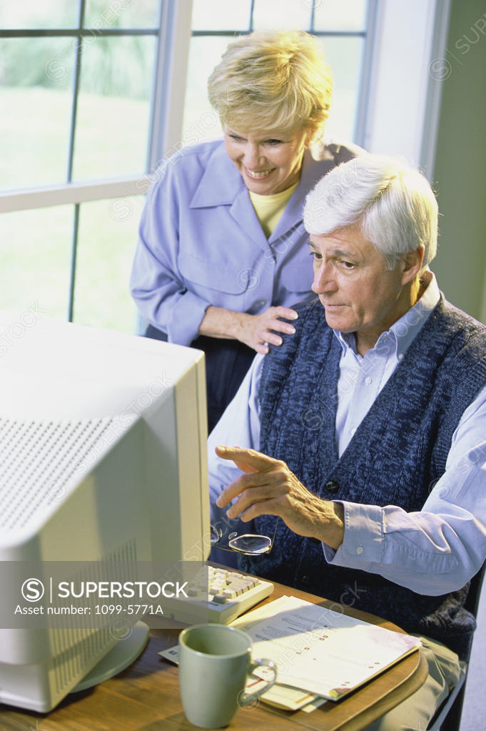 Stock Photo: 1099-5771A Senior couple using a computer
