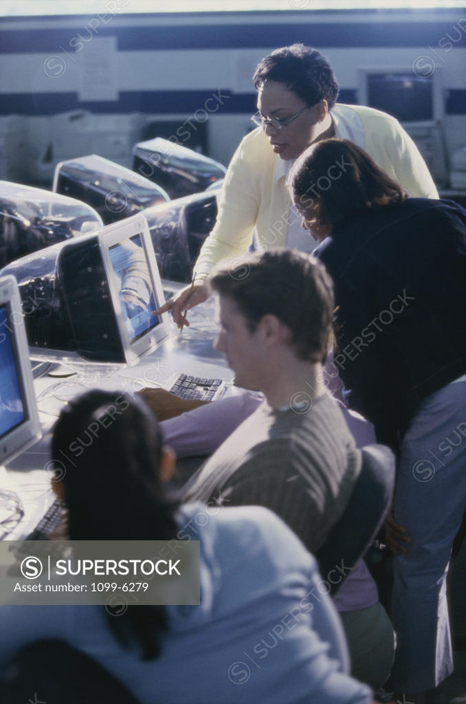 Stock Photo: 1099-6279 Female teacher and her students in a computer class