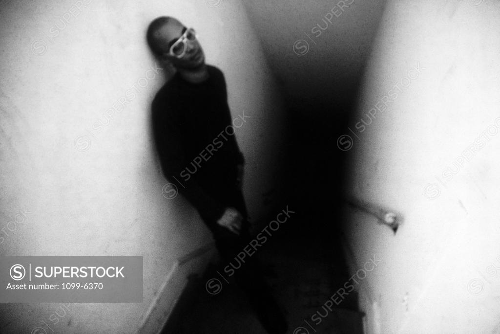 Stock Photo: 1099-6370 Young man leaning against a wall