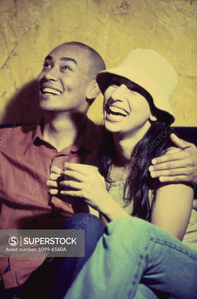 Stock Photo: 1099-6560A Young couple sitting together laughing