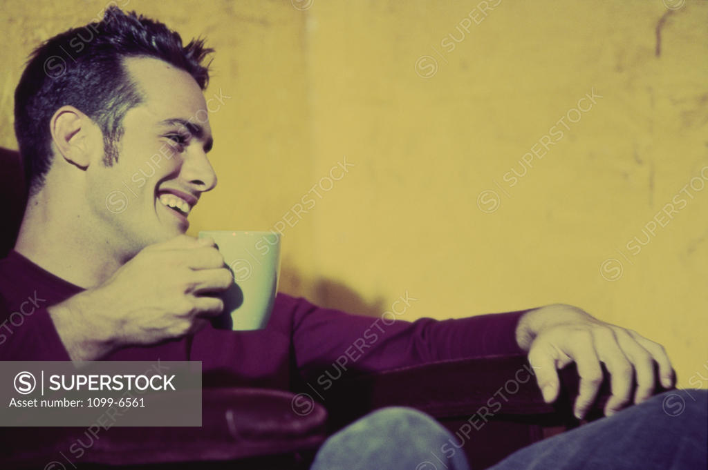 Stock Photo: 1099-6561 Young man holding a cup of coffee