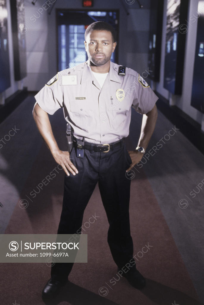 Stock Photo: 1099-6697A Portrait of a male security guard standing with arms akimbo