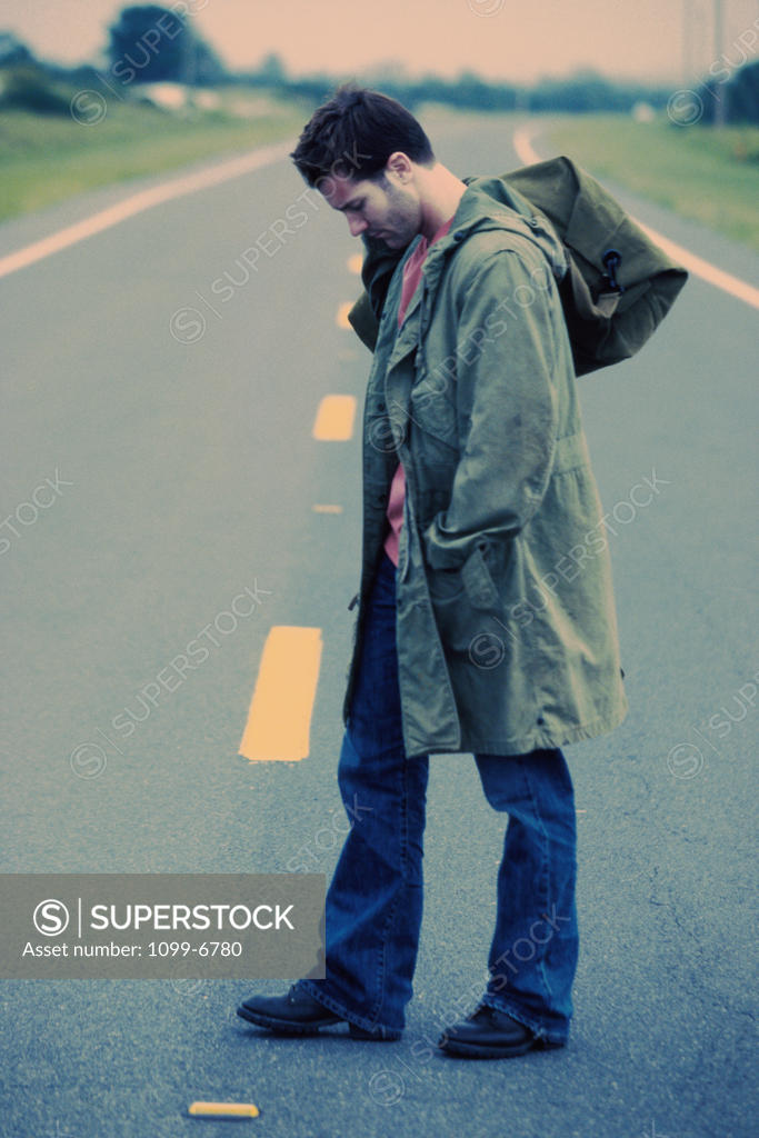 Stock Photo: 1099-6780 Young man standing in the middle of the road