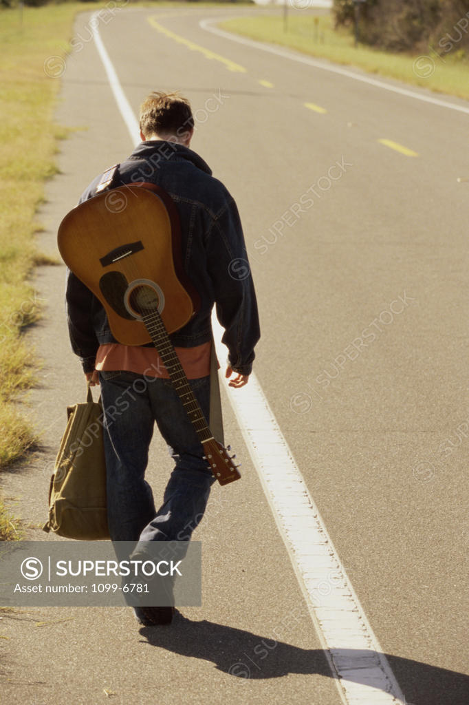 Stock Photo: 1099-6781 Rear view of a young man standing on the side of a road