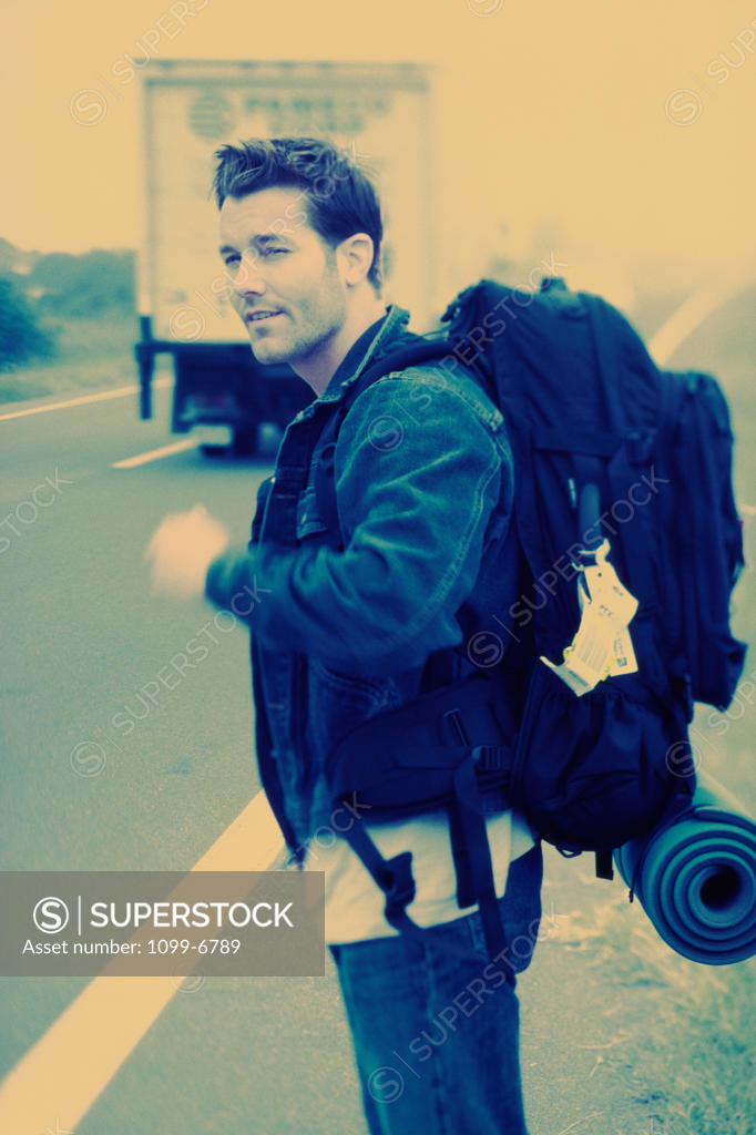 Stock Photo: 1099-6789 Young man standing on the side of a road