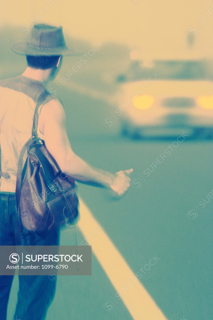 Stock Photo: 1099-6790 Rear view of a young man hitchhiking