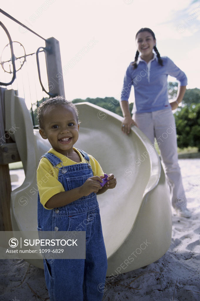 Stock Photo: 1099-6829 Portrait of a teenage girl standing with a baby boy